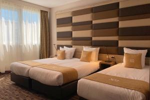 een hotelkamer met 2 bedden en een groot raam bij XO Hotels Blue Square in Amsterdam