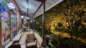 uma sala com bancos, plantas e árvores em Kampoeng Semar Borobudur em Magelang