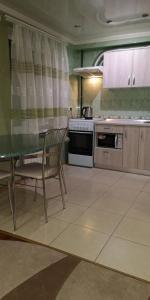a kitchen with a table and chairs and a stove at Уютная квартира возле CITY Mall in Zaporozhye