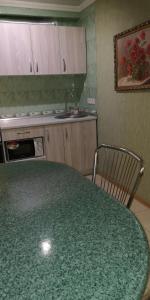a kitchen with a green table and a sink at Уютная квартира возле CITY Mall in Zaporozhye
