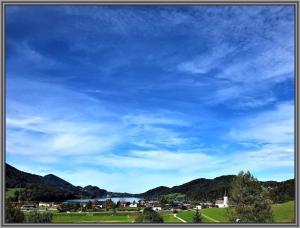 widok na niebieskie niebo z polem i góry w obiekcie Casa Bicicletta w mieście Fuschl am See