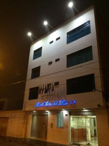 a white building with a sign on it at night at Hotel Viña del Mar in Tacna