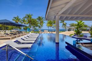 a pool with lounge chairs and umbrellas at a resort at Royalton Grenada, An Autograph Collection All-Inclusive Resort in Bamboo +191 photos