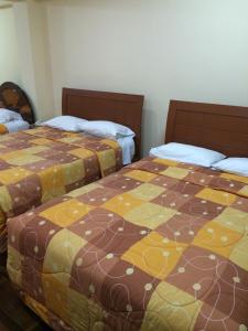 two beds sitting next to each other in a room at Hotel Viña del Mar in Tacna