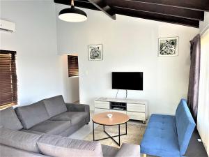 a living room with a couch and a tv at 63 Cest Si Bon - Shelly Beach in Shelly Beach
