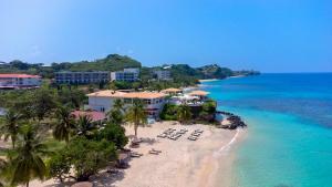 an aerial view of a beach with chairs and the ocean at Royalton Grenada, An Autograph Collection All-Inclusive Resort in Bamboo