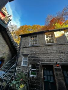 a brick building with a staircase leading up to it at The Well House Boutique Cottage Hebden Bridge Central in Hebden Bridge