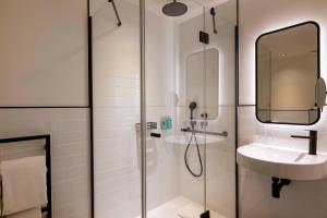 a bathroom with a shower and a sink and a mirror at Le 12 Hôtel in Paris