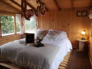 - une chambre avec un lit dans une cabane en rondins dans l'établissement ALMA Glamping - San Francisco Cund - A 1h de Bogotá, à San Francisco