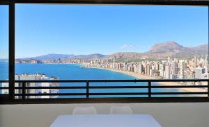 Zimmer mit einem Tisch und Stühlen und Meerblick in der Unterkunft Trinisol Sea views 24E in Benidorm