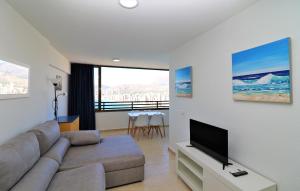 ein Wohnzimmer mit Couch und Flachbildfernseher in der Unterkunft Trinisol Sea views 24E in Benidorm