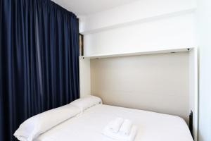 Bett in einem Zimmer mit einem blauen Vorhang in der Unterkunft Trinisol Sea views 24E in Benidorm + 18 Fotos