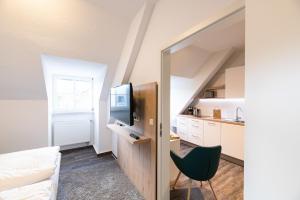 a room with a bed and a tv and a kitchen at Altes Wasserwerk, FW 7 in Zingst