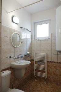 a bathroom with a sink and a toilet and a window at Семеен хотел Орфей in Teshel