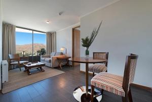 a living room with a table and chairs and a couch at Hotel Atacama Suites in Copiapó