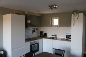 a kitchen with white cabinets and a sink at TERRASSES DE MALMEDY Triplex 224 LE CERF BLANC in Malmedy