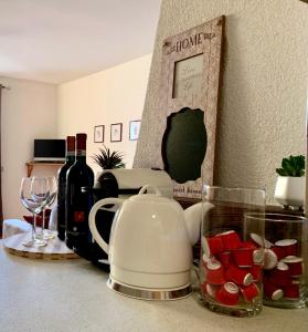 a counter top with a tea kettle and wine bottles at Cima de’ Piazzi Apartment in Isolaccia