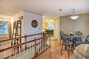 a living room with a staircase and a table and chairs at Lake Barkley Home with Fire Pit and Private Dock! in Cadiz