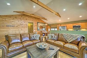 a living room with leather couches and a table at Peaceful Banner Elk Mountain Cabin Near Ski Areas! in Banner Elk