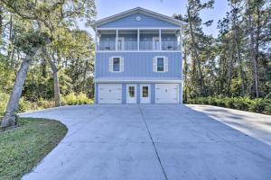 a blue house with a garage on a driveway at Modern Escape in the Heart of Murrells Inlet in Myrtle Beach