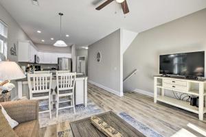 a living room with a couch and a tv and a kitchen at Modern Escape in the Heart of Murrells Inlet in Myrtle Beach