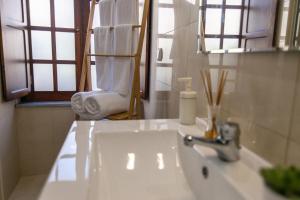 a bathroom with a sink and a mirror and a chair at Barrote Beja- Alojamento Local in Beja