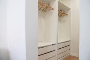 a walk in closet with white cabinets and a mirror at Charming 1 Bedroom Apartment w/ Terrace Near Belém in Lisbon