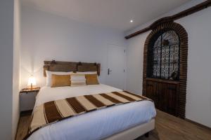 a bedroom with a large bed and a window at Barrote Beja- Alojamento Local in Beja