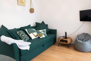 a living room with a green couch with pillows at Charming 1 Bedroom Apartment w/ Terrace Near Belém in Lisbon
