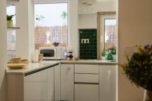 een keuken met witte kasten en een magnetron bij Charming 1 Bedroom Apartment w/ Terrace Near Belém in Lissabon