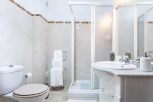 een badkamer met een toilet, een wastafel en een douche bij As Andorinhas in Portimão