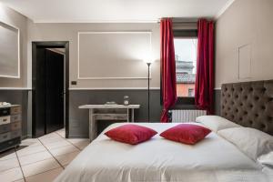 ボローニャにあるStudio Fusari a Piazza Maggiore by Wonderful Italyのベッドルーム1室(赤い枕2つ付きのベッド1台付)