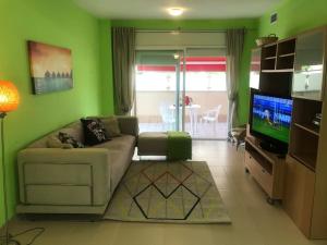 sala de estar con sofá y TV de pantalla plana en Acogedor apartamento a 200m del mar, en Lloret de Mar