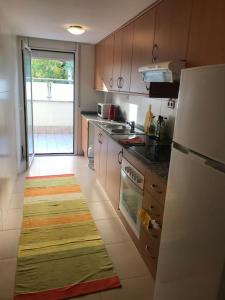 cocina con nevera y alfombra en el suelo en Acogedor apartamento a 200m del mar, en Lloret de Mar