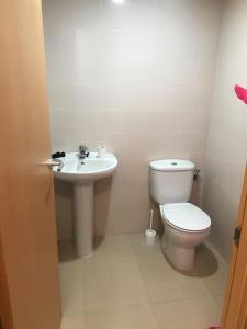 Baño blanco con aseo y lavamanos en Acogedor apartamento a 200m del mar, en Lloret de Mar