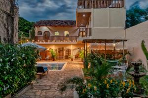 格拉纳达Boutique Hotel Secret Garden Granada的一座带庭院和游泳池的房子