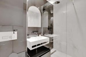 巴黎的住宿－CMG Lamartine-Maubeuge，白色的浴室设有2个盥洗盆和淋浴。