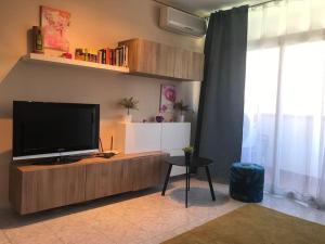 sala de estar con TV de pantalla plana en un centro de entretenimiento de madera en Bonito apartamento a 250m del mar en Lloret de Mar