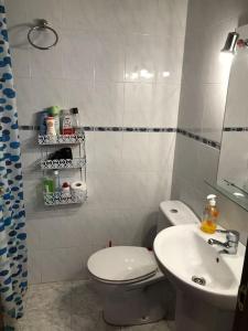 y baño con aseo blanco y lavamanos. en Bonito apartamento a 250m del mar en Lloret de Mar