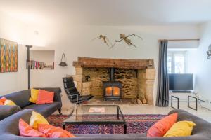 een woonkamer met twee banken en een open haard bij The Barracks in Northleach