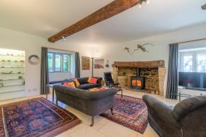 een woonkamer met een bank en een open haard bij The Barracks in Northleach