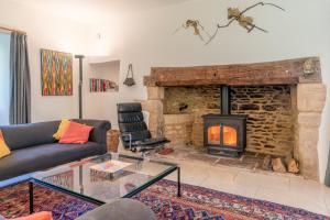 een woonkamer met een bank en een open haard bij The Barracks in Northleach