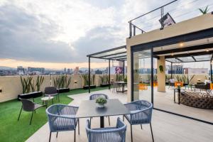 an outdoor patio with tables and chairs on a roof at ULIV Luxe Apartments Polanco in Mexico City
