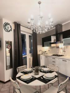 a kitchen with a table and chairs and a chandelier at APPARTAMENTI REPUBBLICA FIERA district in Bologna