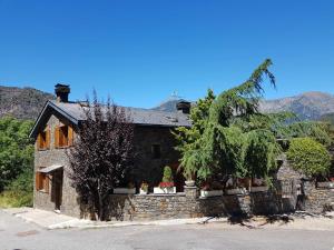 聖胡利婭德洛里亞的住宿－Casita dúplex en Casa Rural Camp de Claror，一座石墙、树木和山脉的房子