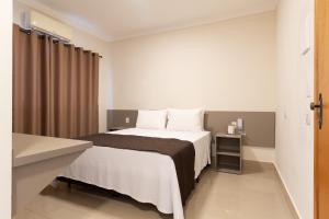 a hotel room with a bed and a table at VILLA NOMAD HOTEL in Uberaba