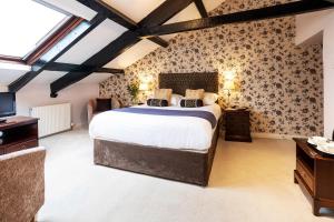 a bedroom with a large bed and a tv at Ees Wyke Country House in Near Sawrey