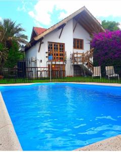 a house and a swimming pool in front of a house at Tanino Guest House in Mendoza