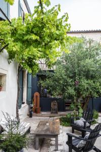 une cour avec des bancs, une table et des arbres dans l'établissement L’Ostréale, à La Tremblade