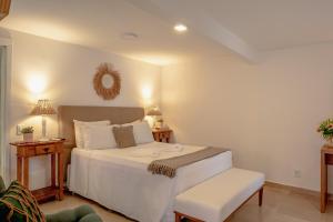 a bedroom with a white bed and a chair at Pousada Blanca Mar in Búzios